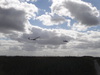 A plane towing a glider into the sky.