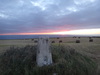 The sun rising over Boulby cliffs trig pillar.