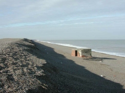 PB100109	Looking west along the shingle beach near Weybourne Hope, with a wartime lookout post on the beach.