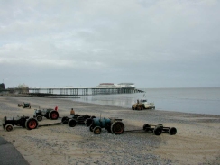 PB250171	A boat being launched onth beach at Cromer, with the pier in the background.