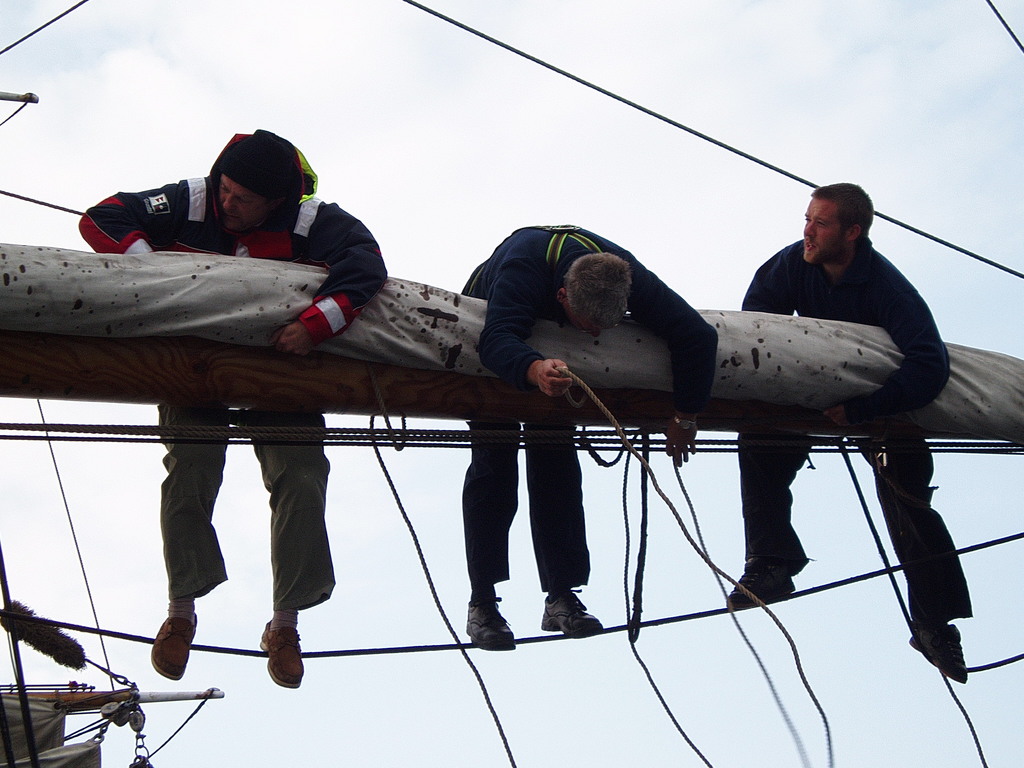 Trying to tie the gaskets around the sails.