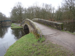 P2019DSC08968	An arch bridge carrying the towpath over the entrance to a lake.