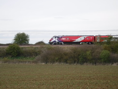 P2019DSCF2921	A train passing St Andrew's Church, Woodwalton.