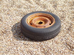 P20108080136	An old car tyre on Chesil Beach.